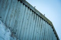 An abstract photograph of two pigeons sitting on a metal barn roof at dusk