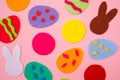 Abstract picture of cut out of felt applications of colourful eggs and white and brown rabbits. Pink background. Flat lay. Easter Royalty Free Stock Photo