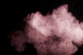 Abstract pink dust explosion on black background.  Freeze motion of pink powder splash Royalty Free Stock Photo