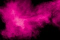 Abstract pink dust explosion on black background.  Freeze motion of pink powder splash Royalty Free Stock Photo