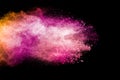 Abstract pink and orange powder explosion on  black background. Freeze motion of pink orange dust splashing Royalty Free Stock Photo