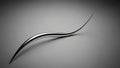 Abstract polished chrome sculpture with a fluid, and dynamic curved form resting on a smooth gray gradient background Royalty Free Stock Photo