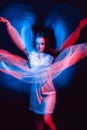 Abstract portrait of a dancing girl in a dress with neon red and blue light Royalty Free Stock Photo