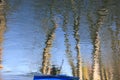 Portrait image of trees and rower reflection on a river