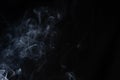 Abstract puffs of smoke on the left side of the frame on a dark background with a place for text, mysticism, fantasy