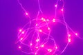 Abstract purple background surface of illuminated pink garland