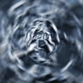 Abstract radial zoom tunnel of crumpled silver aluminum foil closeup background texture pattern in blue