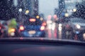 Abstract rain droplets on car windshield with bokeh of traffc at twilight for background Royalty Free Stock Photo