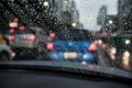 Abstract rain droplets on car windshield with bokeh of traffc at twilight for background Royalty Free Stock Photo