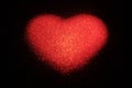 Abstract red heart made of shiny dots on a black background. The concept of congratulations on Valentine`s Day, love blank,