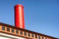 Abstract of a red smoke stack against blue sky