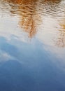 Abstract reflection background yellowed trees, sky with clouds in autumn in the blue water of the river Royalty Free Stock Photo