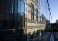 Abstract reflection of a building on a glass wall with the building's name visible in the reflection