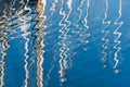 Abstract Reflection of colorful sailboats masts on a rippled water surface