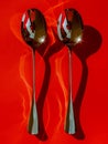 Abstract Reflections on Spoons with Vivid Red Shadow Patterns for Artistic Background