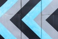 Abstract repeating blue, black and gray arrows on building wall. Strategy and direction concept