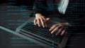 Abstract representation of coding and programming activity with a person typing on a laptop illuminated by digital data Royalty Free Stock Photo