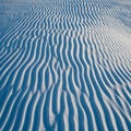 Abstract Ripples of White Sand Dunes Under Blue Sky Royalty Free Stock Photo