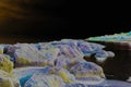 Abstract Rocky Beach at Night with Cityscape Behind. A Bright Filter Creates a Fantastic Look