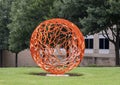 Abstract round orange painted metal sculpture in the Telecom Corridor in Richardson, Texas.