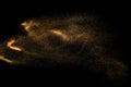 Abstract sand cloud. Golden colored sand splash against dark background. Royalty Free Stock Photo