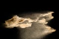 Abstract sand cloud.Golden colored sand splash agianst dark background.Yellow sand fly wave in the air. Royalty Free Stock Photo