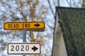 An abstract sarcastic look at the year 2020. Sign post with arrows showing 2020 and `Dead End`