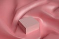A pink cube lies on a surface of twisted pink fabric