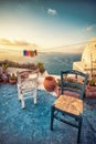 Abstract scene of two wooden chairs on a patio on Santorini.