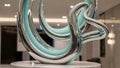 Abstract sculpture with intertwined chrome and turquoise loops on marble base image Royalty Free Stock Photo