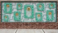 Abstract sculpture recessed in a brick wall along a sidewalk on North Boulevard in Edmond, Oklahoma.