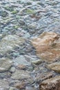 Abstract sea background with water covering stones and pebbles. Vertical orientation Royalty Free Stock Photo