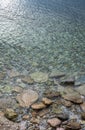 Abstract sea background with water covering stones and pebbles. Vertical orientation Royalty Free Stock Photo