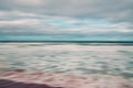 Abstract seascape with blurred panning motion. Overcast day, ocean waves, and cloudy sky.