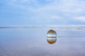 Abstract seascape, glass ball o sand beach at sunset, copy space for text. Relaxation, vacation concept Royalty Free Stock Photo