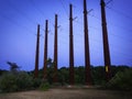 6 Tall Metal Electric Pylons over the Meadow against Big Blue Sky Royalty Free Stock Photo