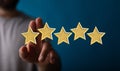 Abstract shot of man touching 3D rendered golden rating stars with a 5-star rank