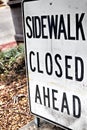 Abstract sidewalk closed ahead sign with plants