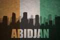 Abstract silhouette of the city with text Abidjan at the vintage ivorian flag