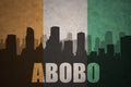 Abstract silhouette of the city with text Abobo at the vintage ivorian flag