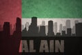 Abstract silhouette of the city with text Al Ain at the vintage united arab emirates flag