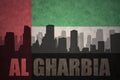 Abstract silhouette of the city with text Al Gharbia at the vintage united arab emirates flag