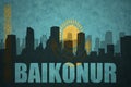 Abstract silhouette of the city with text Baikonur at the vintage kazakhstan flag