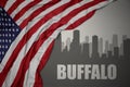 Abstract silhouette of the city with text Buffalo near waving national flag of united states of america on a gray background Royalty Free Stock Photo