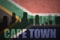 Abstract silhouette of the city with text Cape Town at the vintage south africa flag