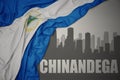 Abstract silhouette of the city with text Chinandega near waving national flag of nicaragua on a gray background. 3D illustration