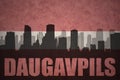 Abstract silhouette of the city with text Daugavpils at the vintage latvian flag