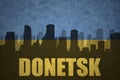 Abstract silhouette of the city with text Donetsk at the vintage ukrainian flag