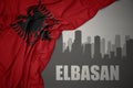 Abstract silhouette of the city with text Elbasan near waving national flag of albania on a gray background