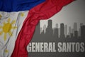 Abstract silhouette of the city with text General Santos near waving national flag of philippines on a gray background.3D
